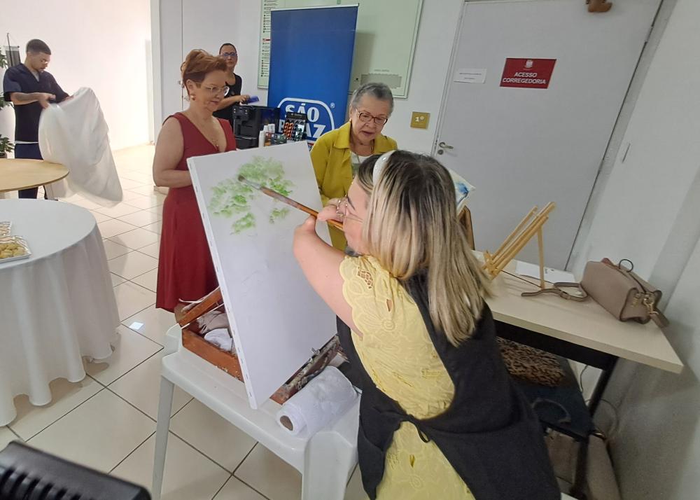 foto de uma pessoa com deficiência pintando paisagem com limitações 